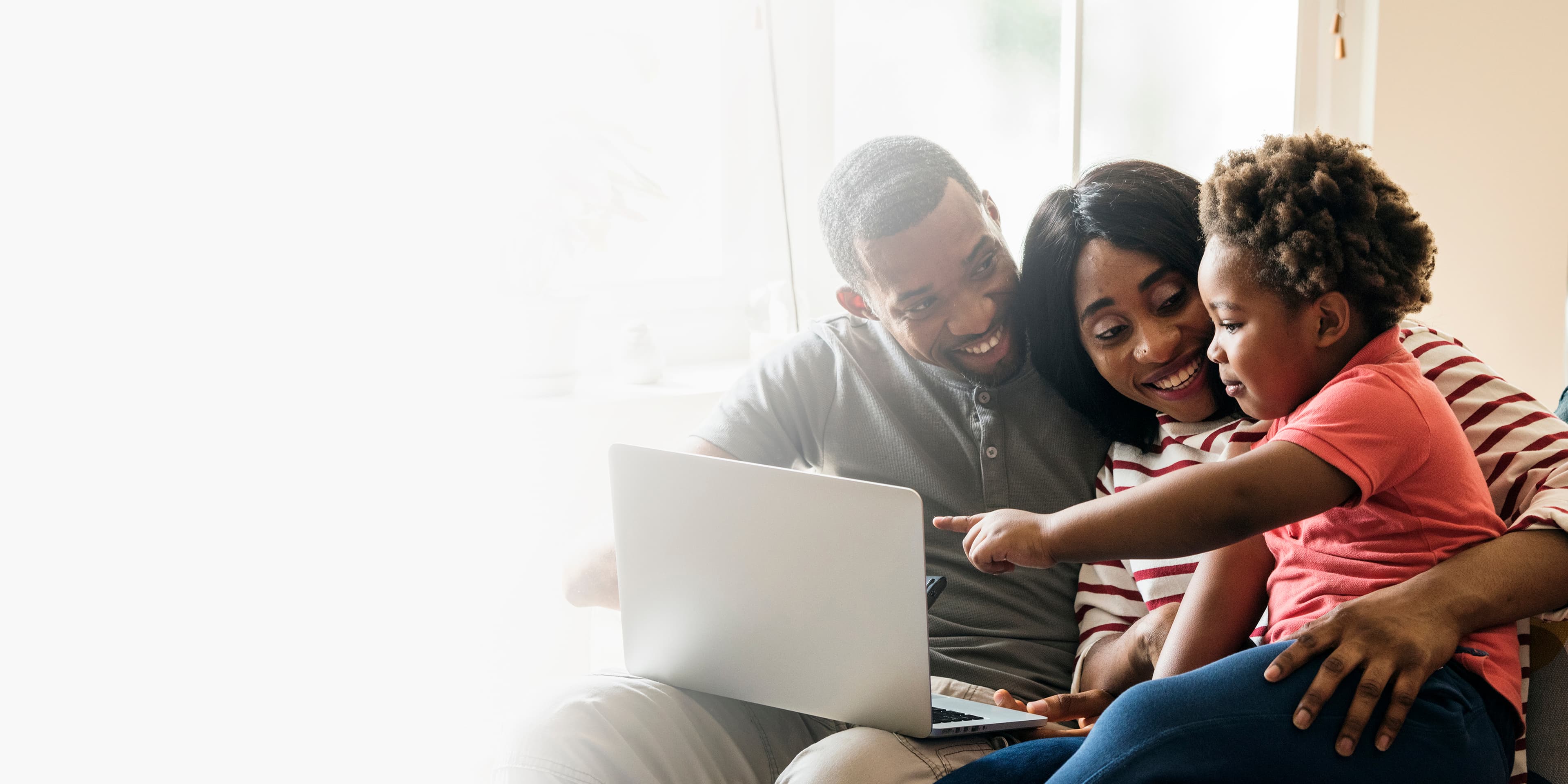 A family happily browsing schools together on a laptop